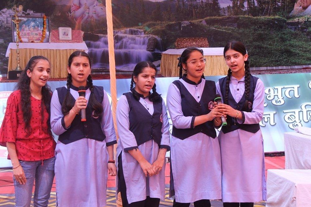 Schoolgirls presenting on the Gita with a microphone