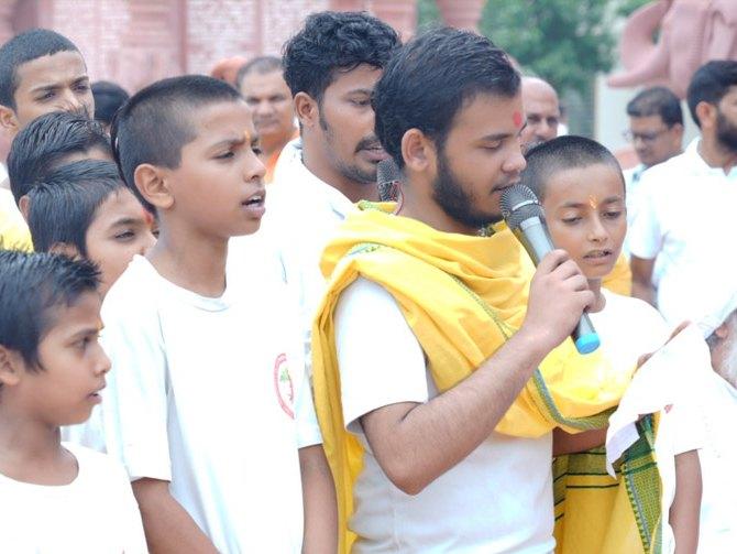 A young student reciting the Gita into a microphone